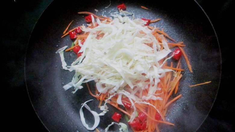 素炒粉丝,放入包菜丝、胡萝卜丝大火爆香