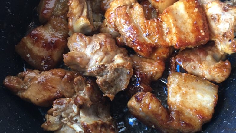 墨鱼干烧肉,等冰糖化开油出现小泡泡时,倒入排骨五花肉翻炒均匀上色