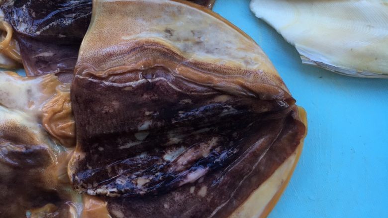 墨鱼干烧肉,去除白色的鱼骨黑色的膜,清洗干净