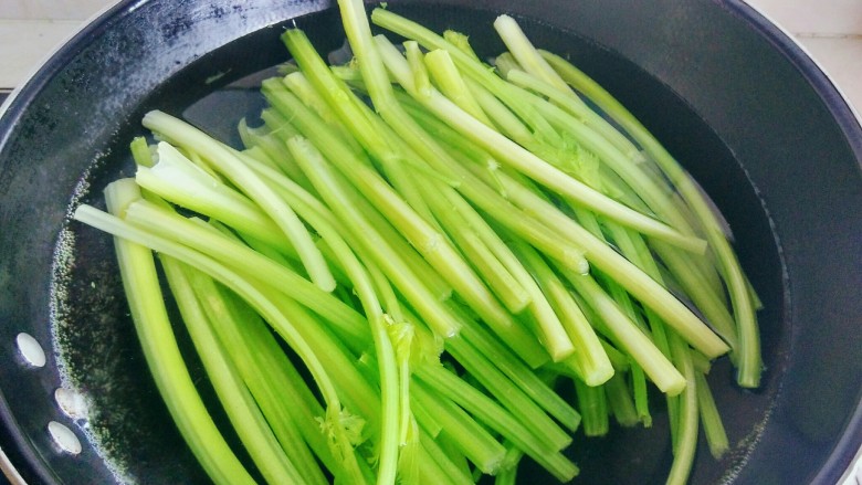芹菜猪肉馅煎包,将芹菜去叶,放开水锅中焯烫2分钟,芹菜变软后捞出。然后将芹菜切碎,用纱布包住,挤出水份。