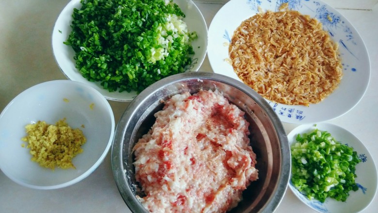 虾皮猪肉馄饨,用生食菜板、菜刀,将老姜剁碎,猪肉剁成比较细碎的馅;用熟食菜板、菜刀,将小香葱切碎,装大盘中的,用于拌馅,装一小盘葱花,用于最后撒在煮熟的馄饨上。