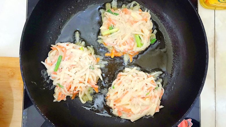 绿色美食+黑胡椒孜然三丝饼,用勺子辅助,把土豆丝面糊摊成圆形!