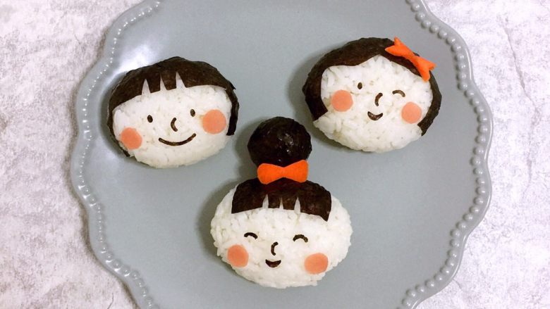 小女孩饭团,6⃣️用海苔压花器做出表情,贴在饭团上。再用<a style='color:red;display:inline-block;' href='/shicai/ 25'>胡萝卜</a>剪出蝴蝶结做装饰,就完成了。