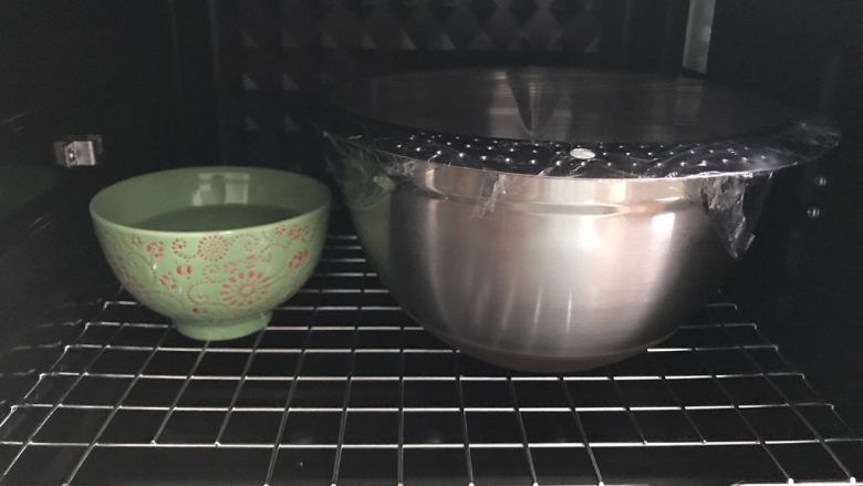 苹果玫瑰吐司,将面团从面包机中取出,团成圆团,放进干净的容器准备一发。烤箱开发酵档30度,放一碗热水,关上烤箱门,发至两倍大,大概一小时左右
