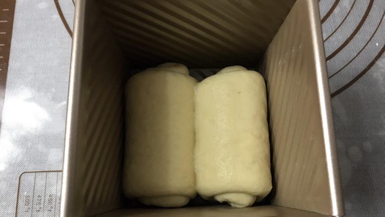苹果玫瑰吐司,卷好两个面团,放入吐司盒中。注意收口方向朝同一边
