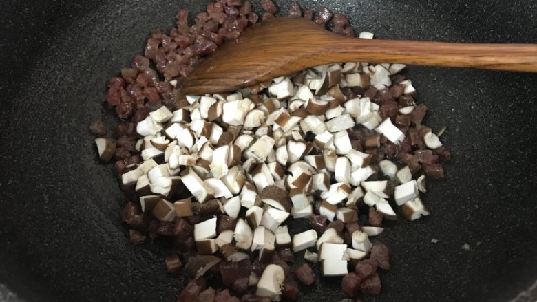 广式烧卖~腊味与海味的完美结合,炒至腊肉出油,加入香菇翻炒均匀