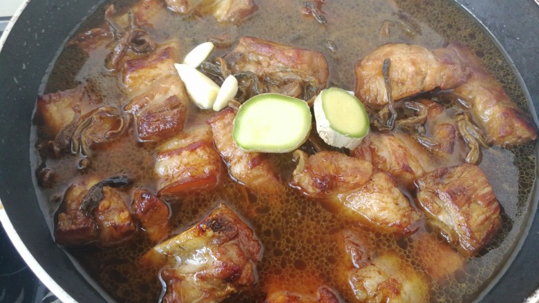 #那一抹家乡味#妈妈菜干豆角烧肉,一碗热水,水刚刚没过肉就可以了,加入生姜和蒜瓣。