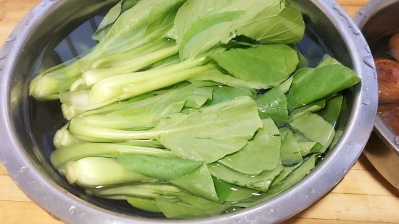 香菇小油菜,青菜洗净、泡入冷水中。水中加入一小勺盐,可以去除农药残留。