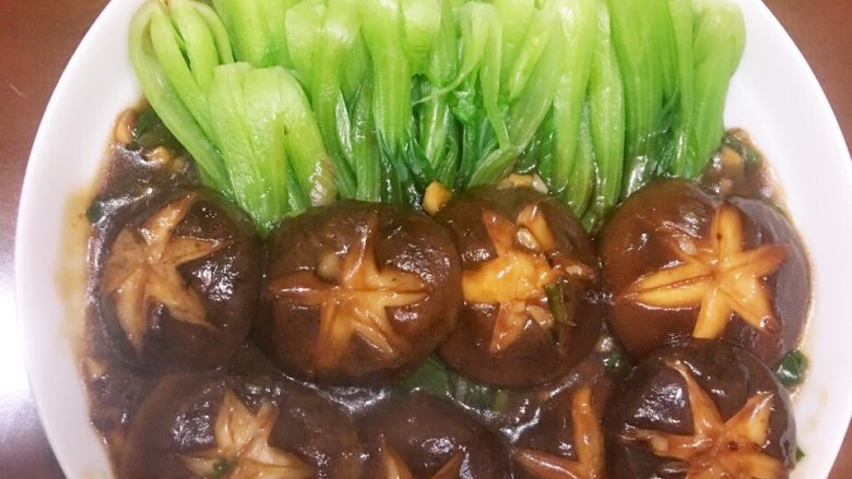 香菇小油菜,装盘时,先浇入烹调好的酱汁,再将香菇摆盘