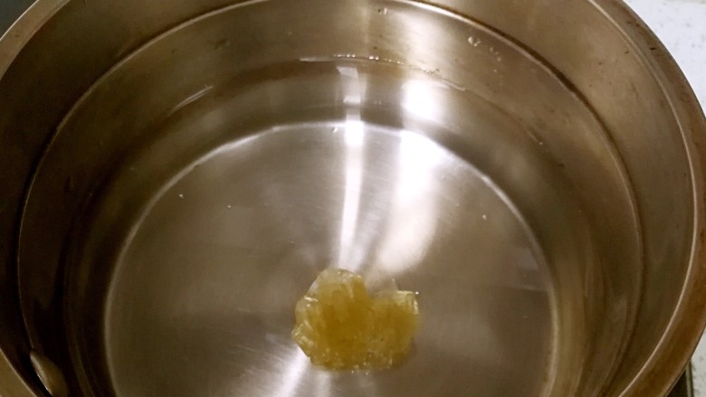青柠百香果热饮,取一小奶锅,倒入清水和冰糖,煮沸,冰糖溶化。