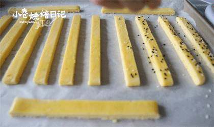 还在吃磨牙棒呢,该换换口味了,切成长条状,表面刷上一层蛋黄液,均匀的撒上黑白芝麻。