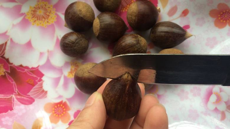 栗子面包,面包机揉面的时候就可以开始制作栗子馅,时间是非常充足的,栗子馅也可以提前制作好。
把栗子清洗干净,用水果刀在栗子尖尖的位置划个十字,这样是为了可以很好的去壳。
