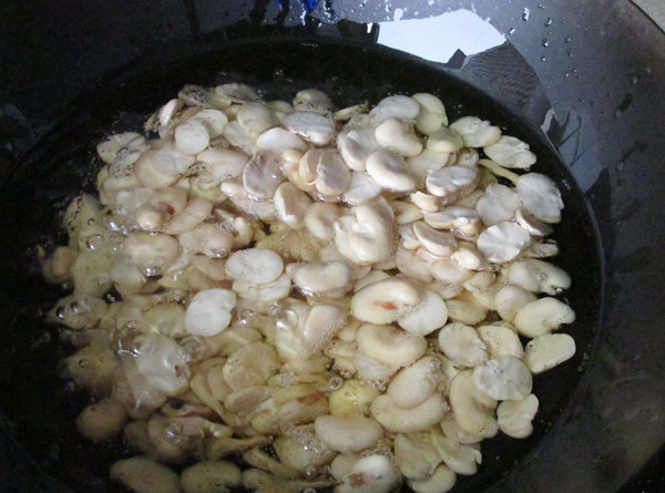怪味胡豆,锅中放油,烧至4成热,把冷冻的蚕豆倒入油里,中火炸