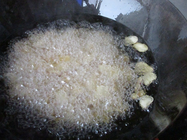 怪味胡豆,炸的时候一开始豆子都沉在锅底,慢慢有飘起了的,要用勺子不断翻动,让其受热均匀