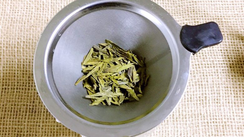 碧螺金桂冰糖饮,杯子放底下,上面放滤网,倒入5克碧螺春