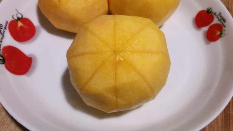 黄桃罐头,从中间花刀对半切开,用小刀或勺子把从后面将黄桃瓣剥下。