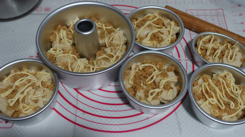 手撕肉松沙拉面包,撒肉松,挤上沙拉酱,再放入面团,如此反复直至放入模具1/2高度即可;