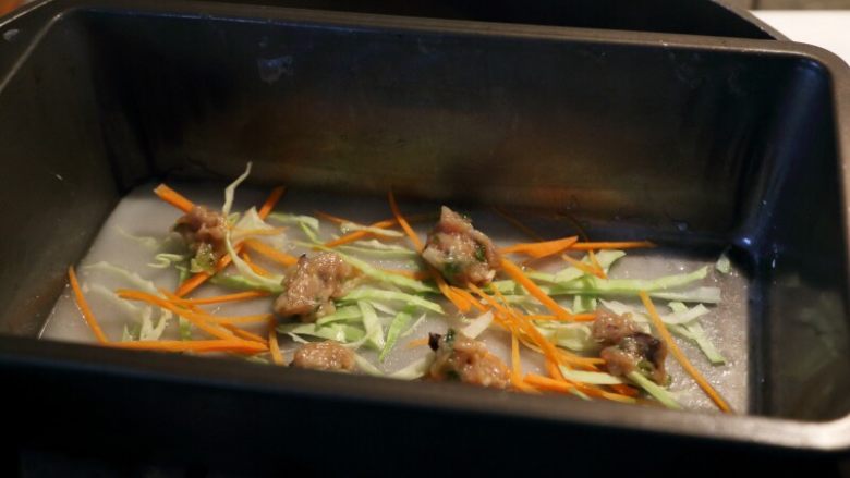 虾子鸡肉肠粉,11.放些胡萝卜丝、包菜丝和一些虾子鸡肉馅料在粉浆上,盖锅蒸。