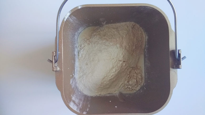 全麦芝麻餐包,再倒入高筋和全麦面粉,面粉要在液体上