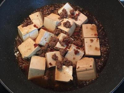 剁椒燒豆腐,放入滾水燙過的豆腐,並小心的將絞肉由鍋底往豆腐上澆淋;