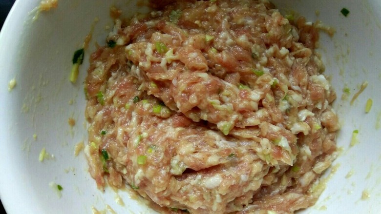 炸格扎夹子,朝一个方向划圈搅拌,打入适量清水,使肉馅上劲搅拌细腻