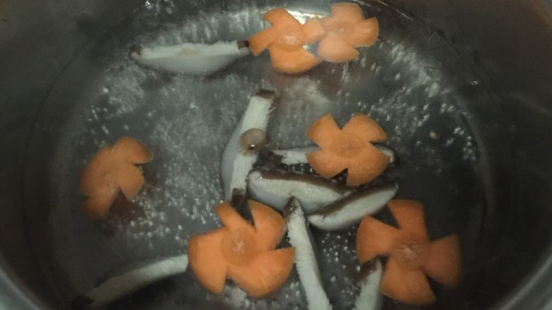 腊肠煲仔饭,锅内烧开水,放入香菇片和胡萝卜片烫半分钟,捞出沥干水分。