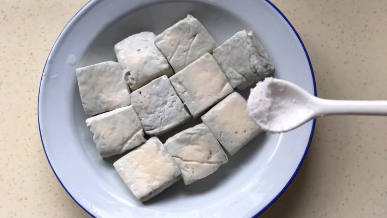 响油臭豆腐,把盐均匀撒在臭豆腐上,可以用手抹匀