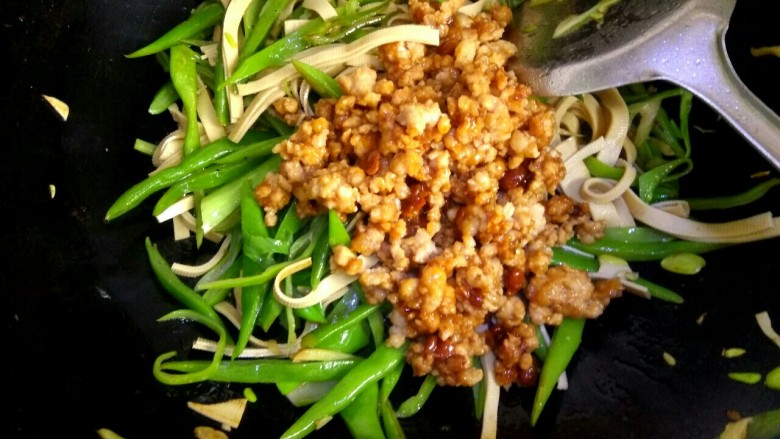 肉沫豆角豆腐丝,倒入肉馅翻炒。把小碗里的调料全部倒入锅中,大火烧开并翻炒均匀关火出锅