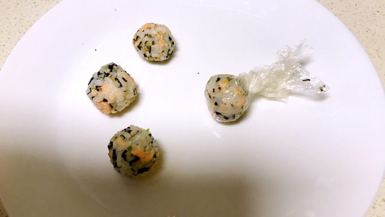 三文鱼紫菜饭团,把保鲜膜提起来捏紧,饭团做好了