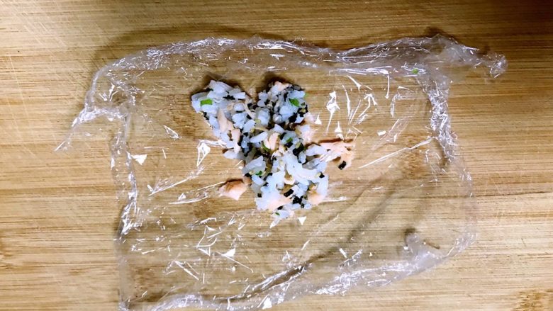 三文鱼紫菜饭团,取一块保鲜膜,上面加入一勺三文鱼紫菜拌饭