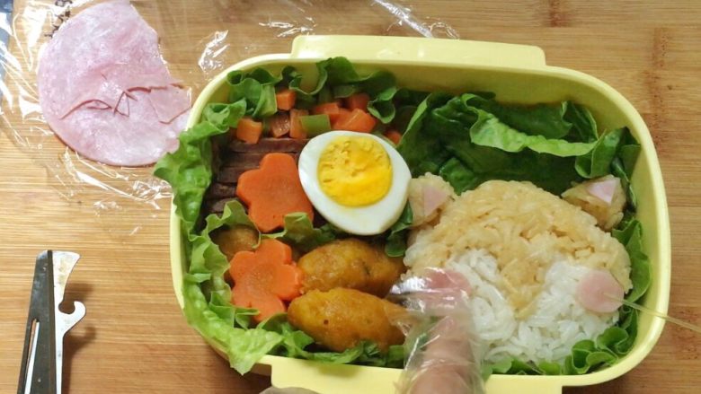猫咪饭团,把火腿片装饰上去,按实。