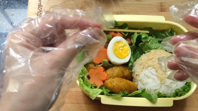 猫咪饭团,脸饭团放到便当盒里,取一根干意面,折成两段2~3㎝的小段。