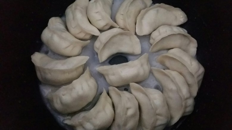 冰花煎饺,调一个水淀粉,水淀粉的浓度和倒入的多少可以决定冰花的薄厚。
水淀粉倒入电饭煲中,以看不到锅底为准。盖上盖子继续煎,大概3-5分钟,水淀粉中的水汽蒸发没,底部干燥即可。