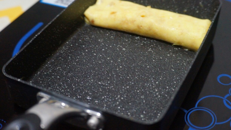 芝士肉松玉子烧,将卷好的第一层推到顶端,锅底刷油。