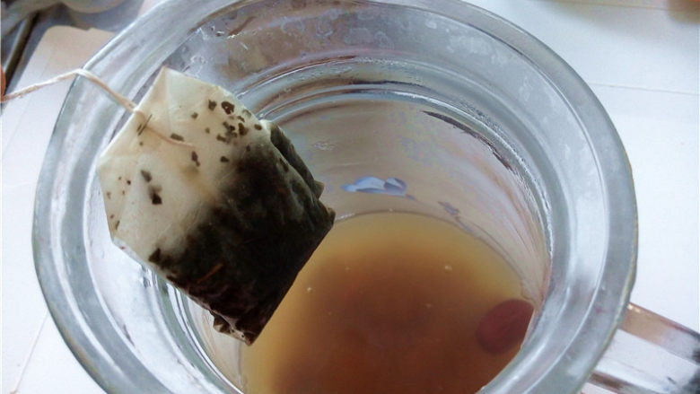 秋冬季养胃暖身最佳饮品--姜枣奶茶,将壶中浸泡的茶包取出来,摇动几下使得茶汤均匀就可以了;
