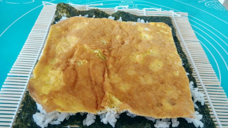 金枪鱼饭卷,将<a style='color:red;display:inline-block;' href='/shicai/ 9'>鸡蛋</a>饼的四边切掉一点,成四方形,铺在米饭上。