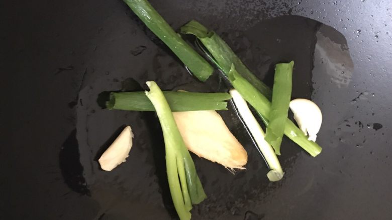 红烧牛肉面,葱切成段,蒜瓣拍碎,热锅冷油爆香葱姜蒜。