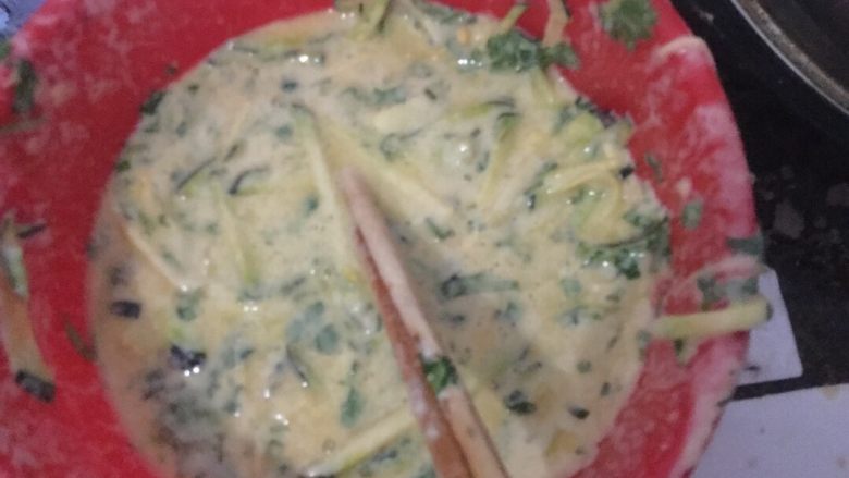 香菜南瓜鸡蛋饼,把香菜剁碎把南瓜切成丝把鸡蛋磕出来放到一个盆中放入水和面搅拌
