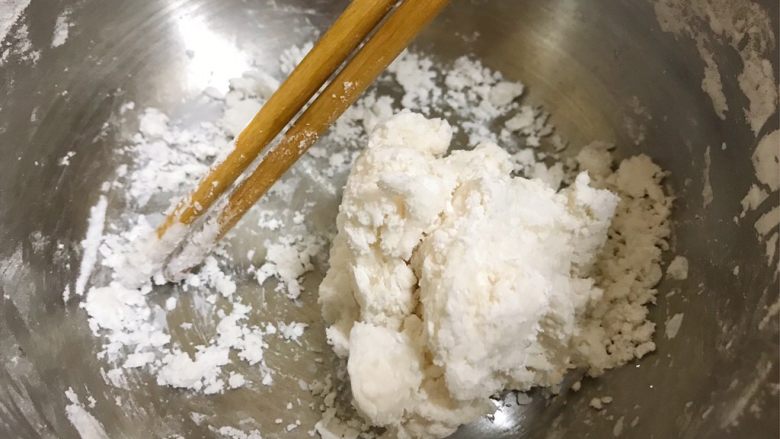 仙草芋圆,取一半木薯粉倒入盆中,倒入14g开水,用筷子搅拌成团