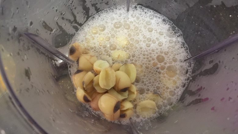 养颜莲蓉雪耳蜜饮,熬煮好雪耳后捞起雪耳,锅里的水连同已煮好的莲子一起倒入搅拌机里打成糊