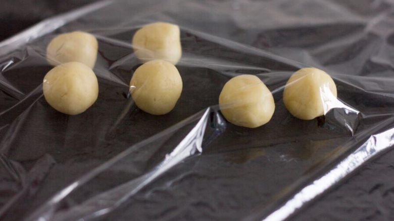 女巫手指饼干,面团冷藏后取出,分成8克或者10克一个的小圆形。烤箱预热180度;(揉成球球的过程当中,推荐用保鲜膜盖着,防止面团风干)