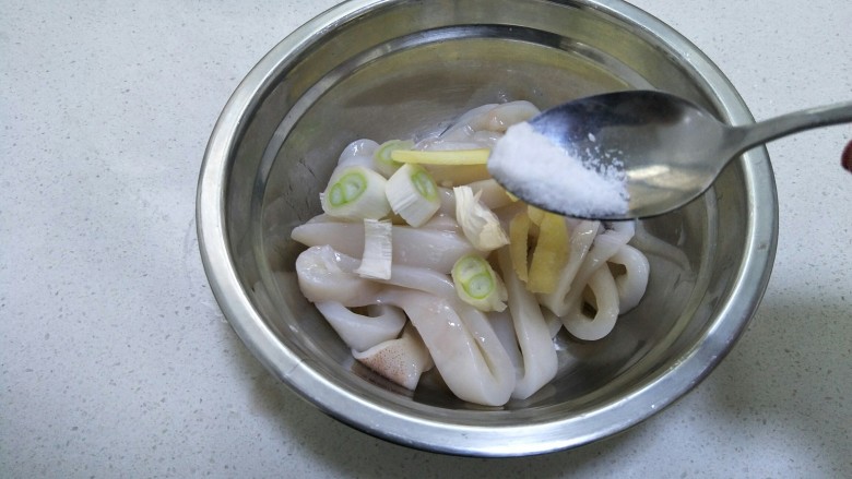 香酥鱿鱼圈,盆里加入料酒,葱段和姜块,再加少许盐。