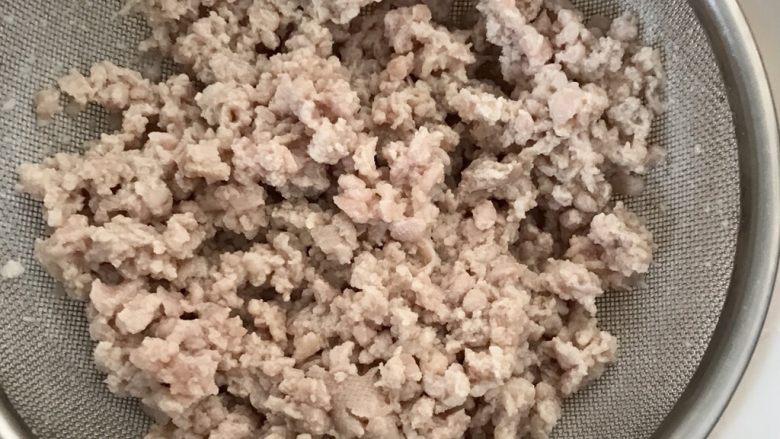 韭菜肉松粥,肉糜放碗中用开水焯烫后沥干。