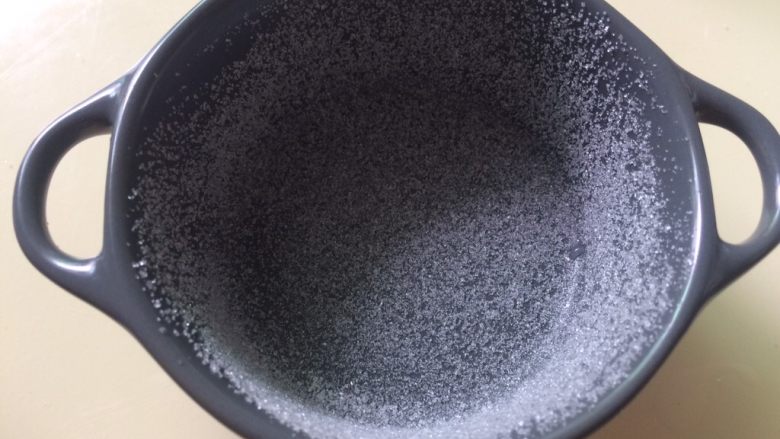 舒芙蕾乳酪蛋糕,白糖放烤碗里转1圈,使白糖沾满烤碗内壁,这样的做法是为了让面糊往上爬升,再轻轻磕一下碗,把多余的糖倒出来。