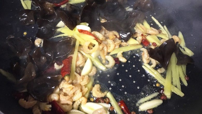 酸辣白菜木耳炒虾米,倒入木耳,翻炒