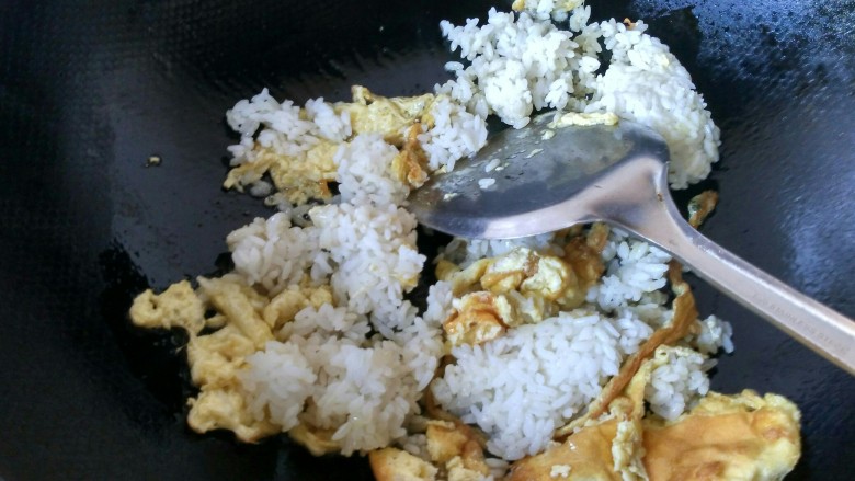 五彩炒饭,把剩米饭倒入锅中,将米饭炒散。