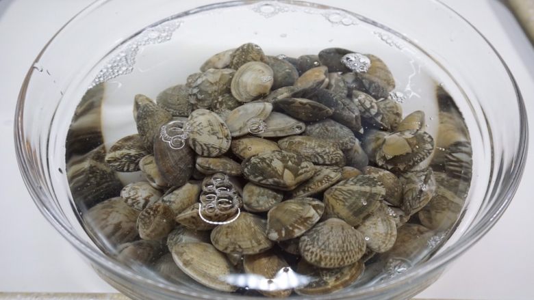 葱油花蛤,加入冷水,一定要盖过花蛤,可以取大一点的碗或盘子,尽量多放一些