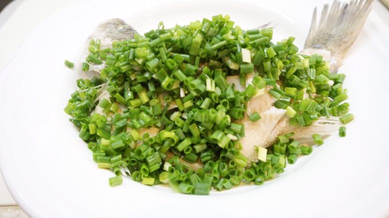 无火鲈鱼,鲈鱼装入盘子中,撒上葱花