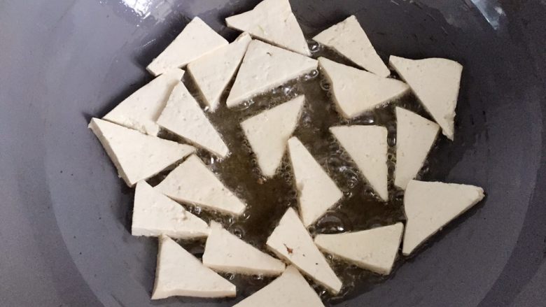 家常豆腐,热锅倒入适量油,油热后放入切好的豆腐煎下