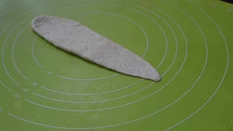 红薯餐包,将松弛好的面团,擀长,呈倒三角形,注意是擀长不是擀宽,擀时左手可辅助提起面团